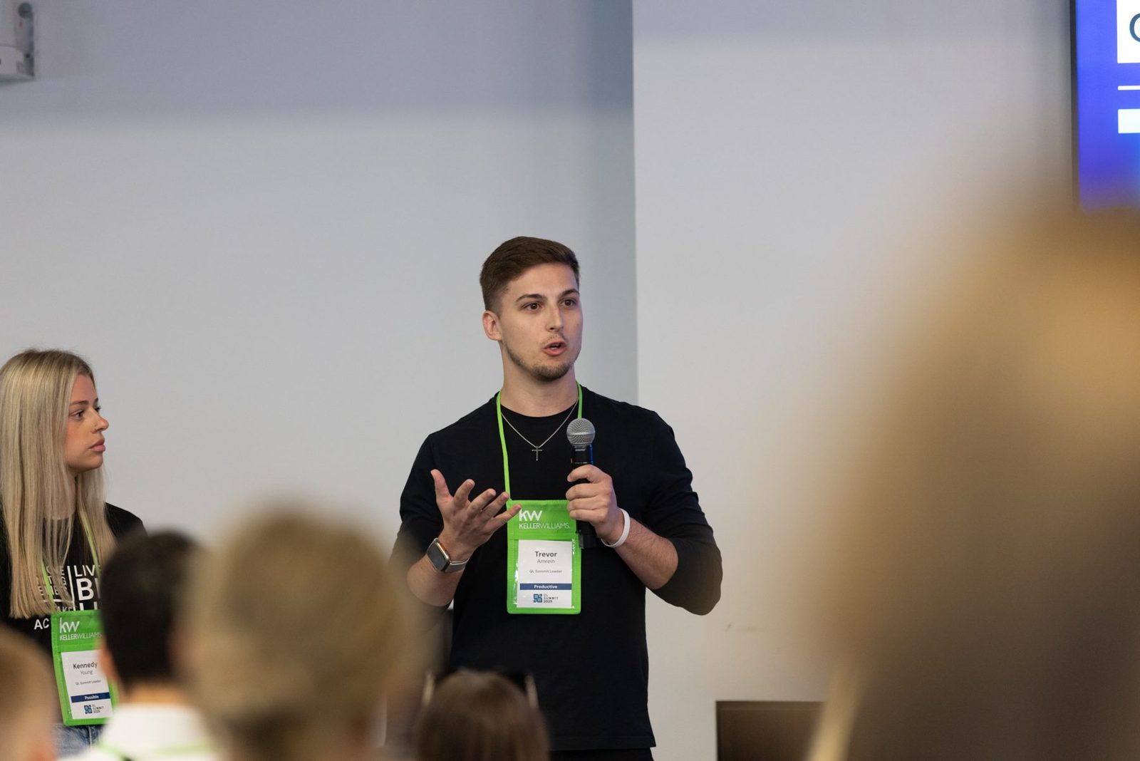 Trevor Amrein on stage with a microphone during a training session