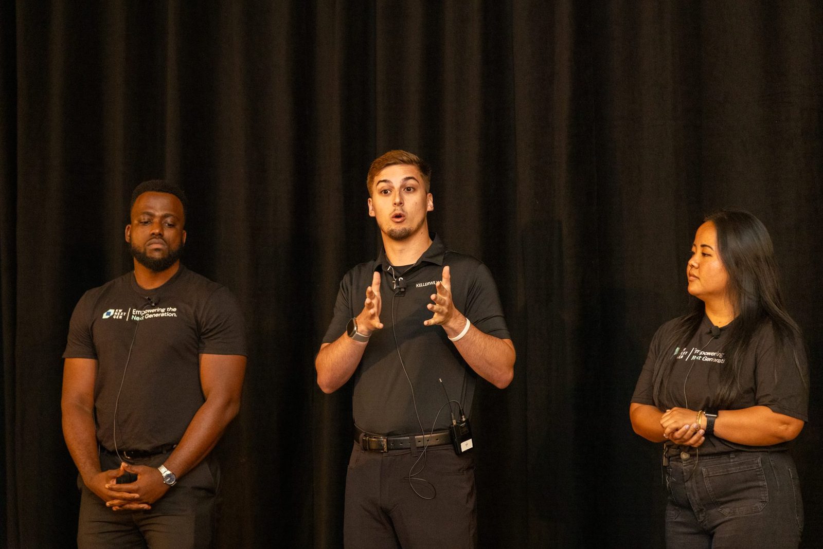 Trevor Amrein presenting on stage with two colleagues