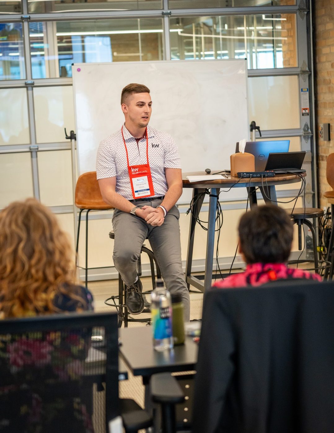 Trevor Amrein teaching a workshop session, whiteboard behind him, audience seated at tables
